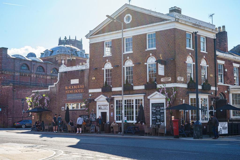 a large brick building with people sitting outside of it at 24 Catharine Street Hotel in Liverpool