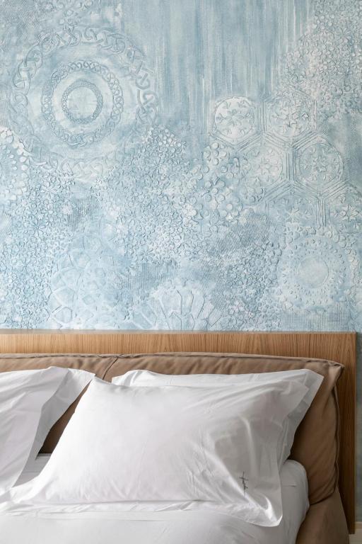 A bed or beds in a room at Ognissanti Restaurant Spa Hotel Rooftop