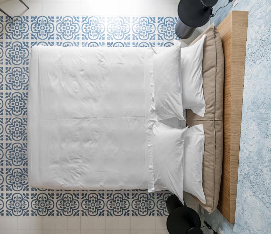 A bed or beds in a room at Ognissanti Restaurant Spa Hotel Rooftop