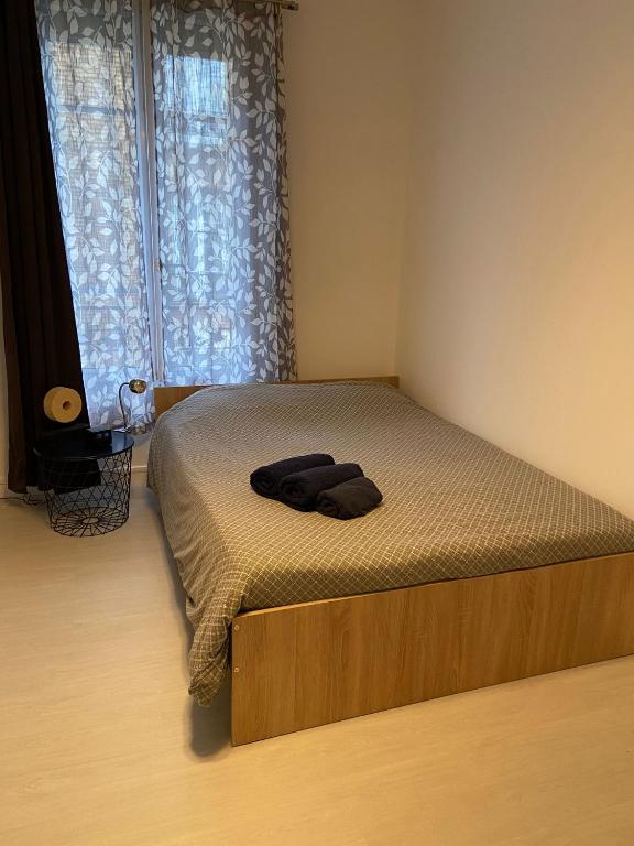 - un lit avec un cadre en bois dans une chambre avec une fenêtre dans l'établissement Studio moderne tout confort, à Champigny-sur-Marne