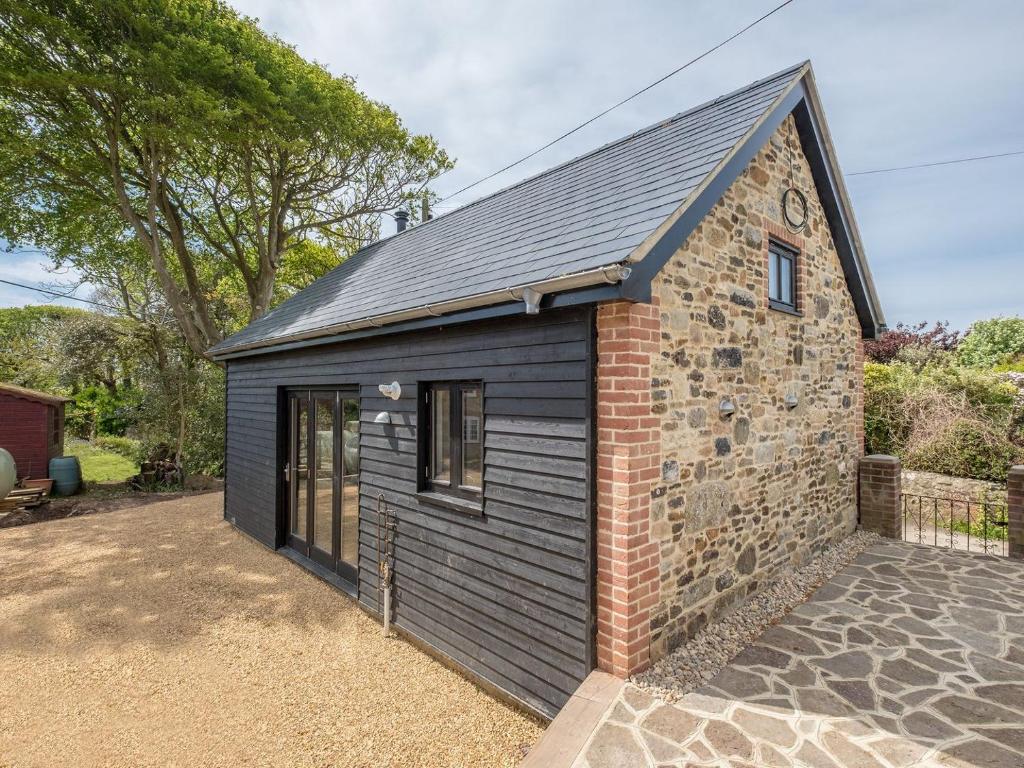 a small black shed with a brick building at Badgers Sett Brook in Brook