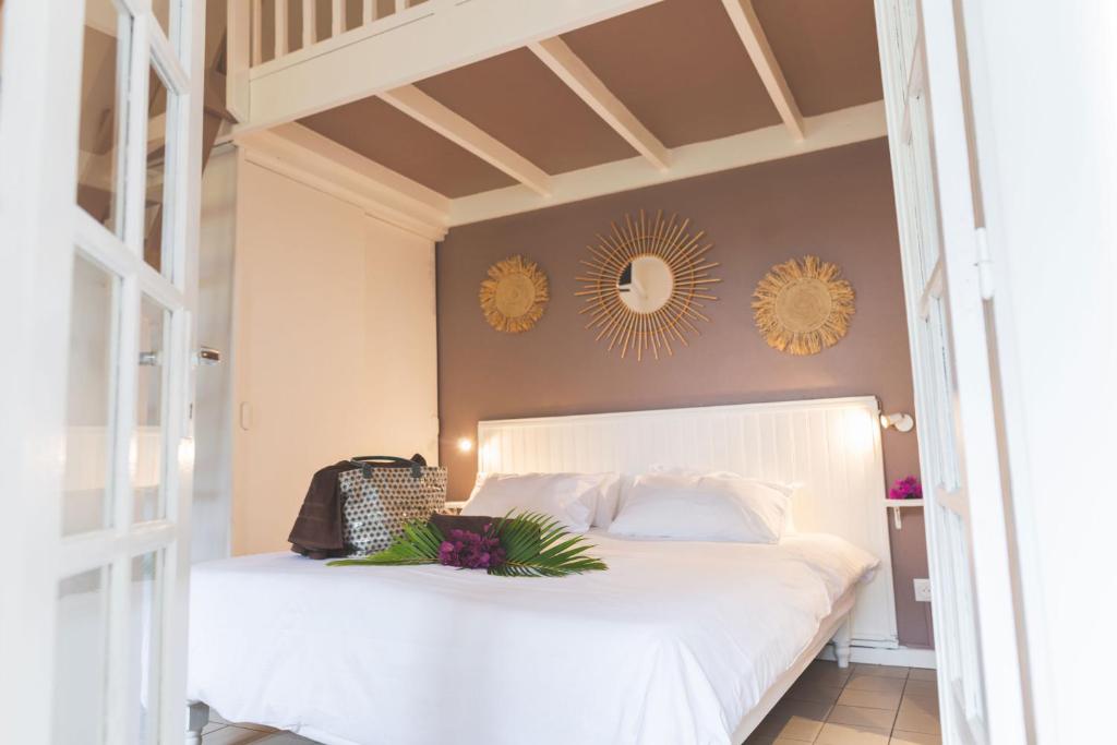 a bedroom with a white bed and mirrors on the wall at Ilet du Lagon in La Saline les Bains