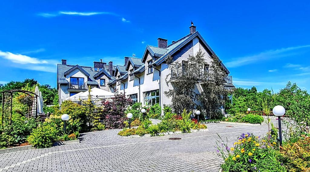 a large house with a garden in front of it at Pensjonat Łysica Wellness & Spa in Święta Katarzyna