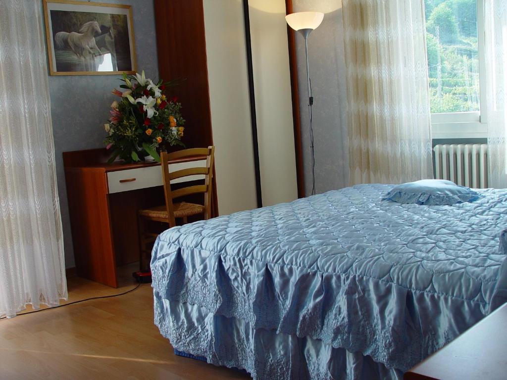 CerianaにあるVecchia Fattoriaのベッドルーム1室(ベッド1台、花瓶付きのテーブル付)