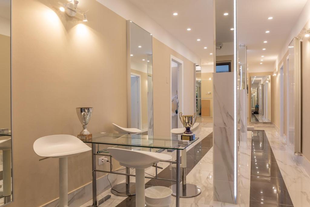 a dining room with a glass table and white stools at Pescara Centro luxury suite II Deluxe Rooms in Pescara