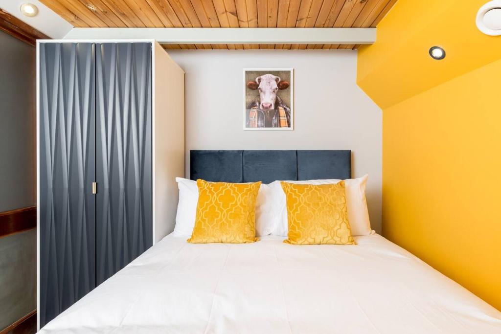 a bedroom with a large white bed with yellow pillows at The Exquisite Duplex of Central Nottingham in Nottingham