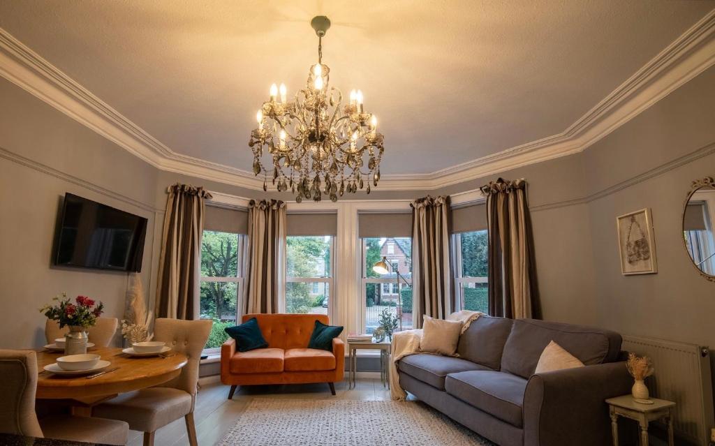 a living room with a couch and a chandelier at Stylish Central 2 Bedroom Apartment in Hereford