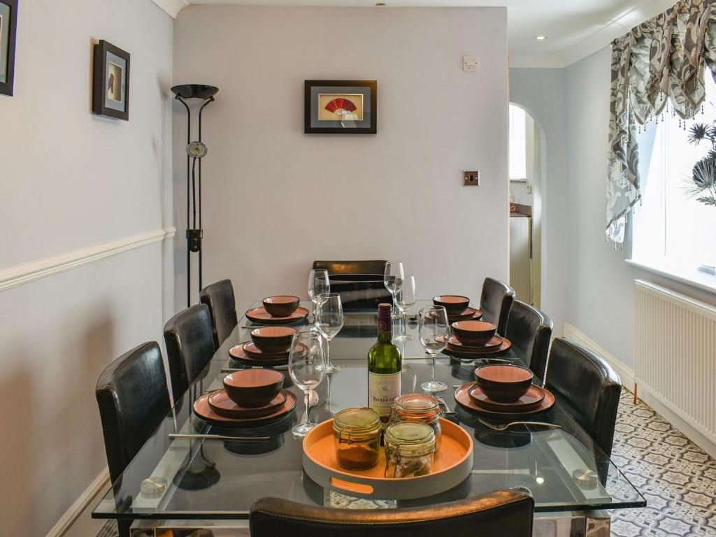 una mesa de comedor con sillas y una botella de vino en The Terrace en Great Yarmouth