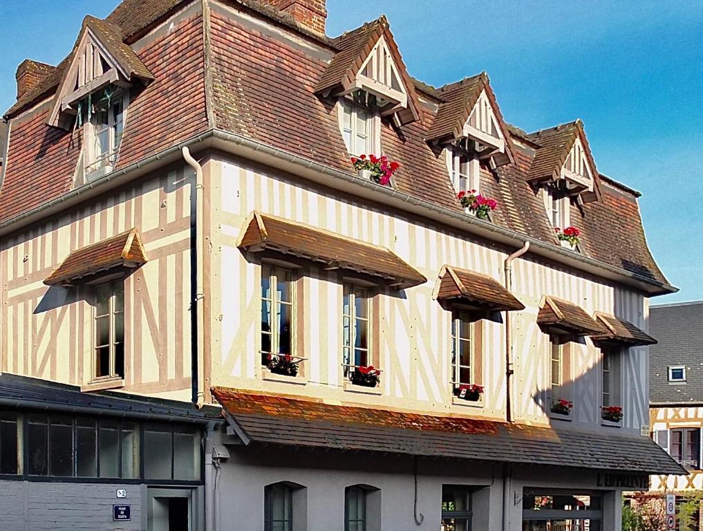 duży budynek z oknami i dachem w obiekcie Centre historique de LYONS LA FORET Hotel de Maître le Cottage w mieście Lyons-la-Forêt