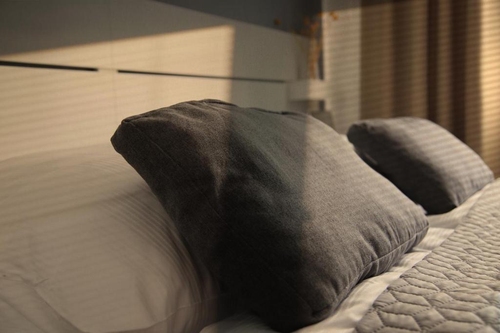 a bed with two pillows on top of it at Boutique Hotel VIVA CREATIVO in Hannover