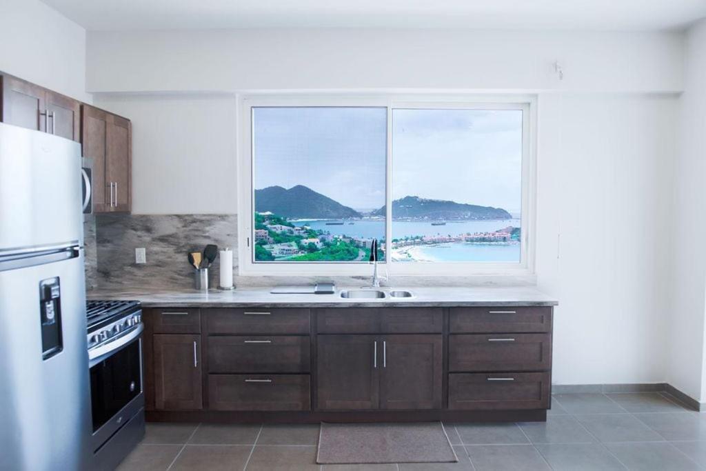 a kitchen with a window with a view of the ocean at Picturesque 1 bedroom apartment in Koolbaai