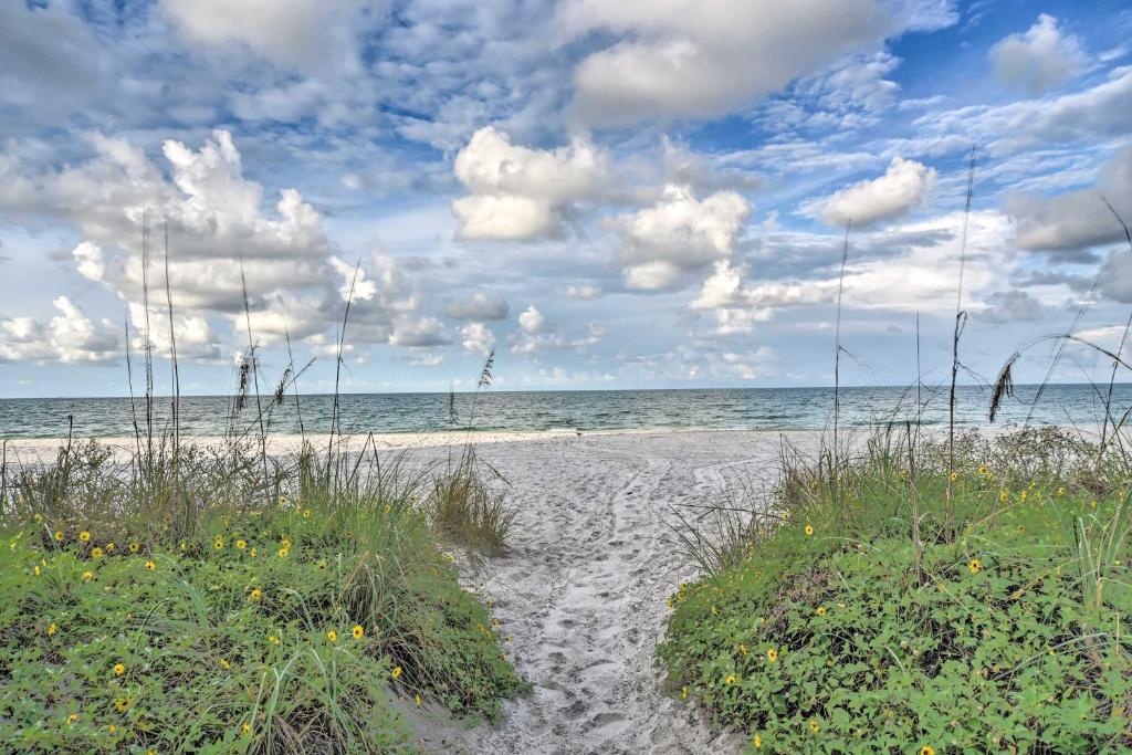 une plage de sable aux mauvaises herbes et à l'océan par une journée nuageuse dans l'établissement Beachfront Madeira Beach Condo with Ocean Views, à St. Pete Beach