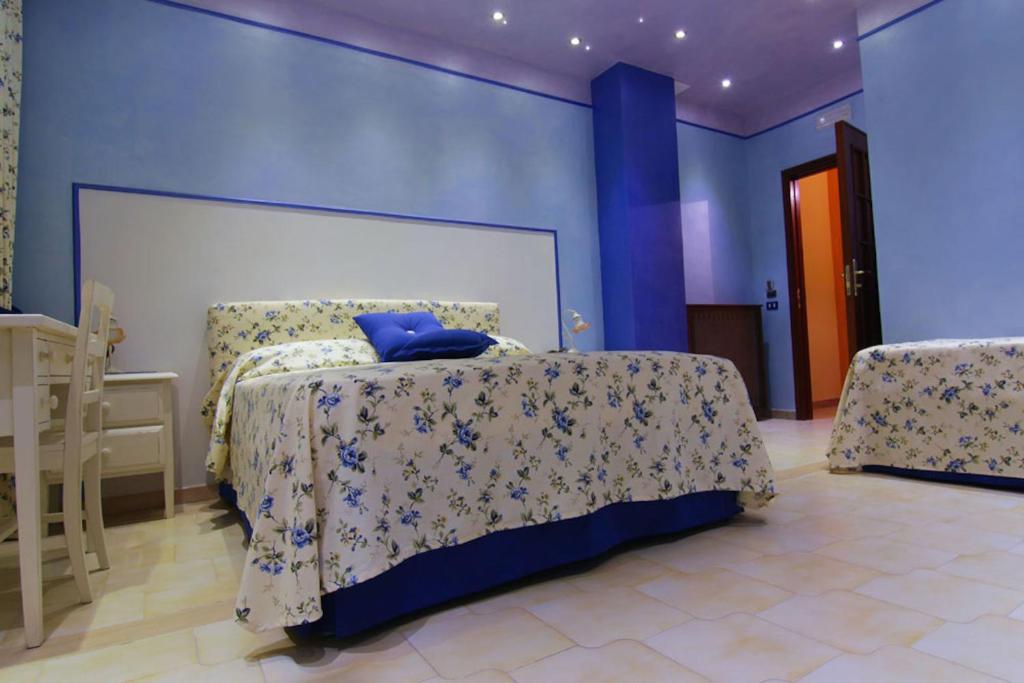 a bedroom with a bed with a blue wall at Villa Delle Camelie in Gragnano
