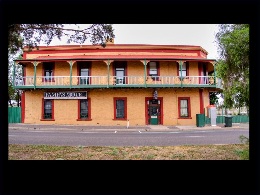 um edifício laranja com uma varanda numa rua em Pampas Motel Port Augusta em Port Augusta