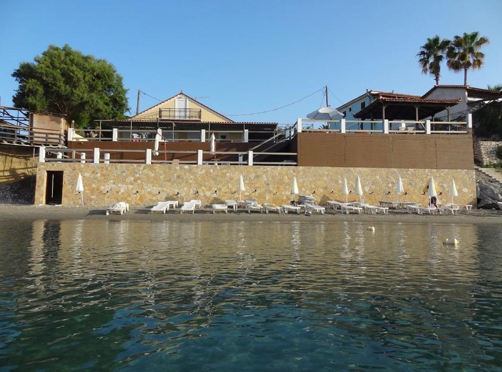 a group of chairs sitting on the shore of the water at Villa Mare Zakynthos, private in Laganas
