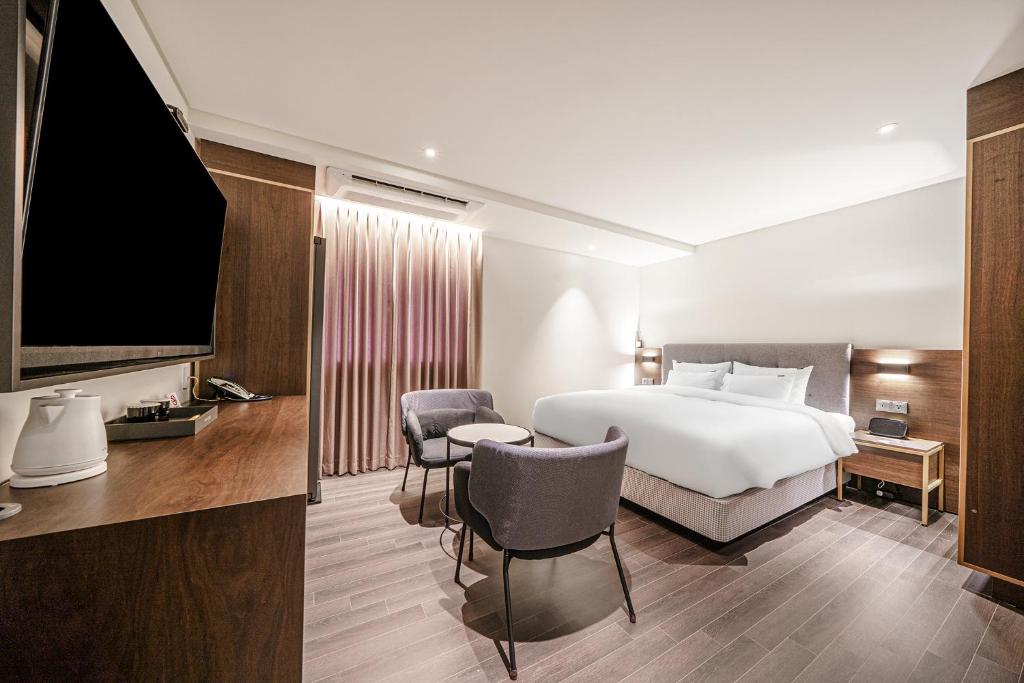 木浦的住宿－Hotel Yaja Mokpo Peace Square，配有一张床和一台平面电视的酒店客房