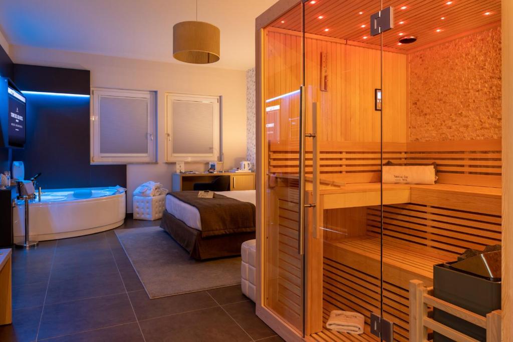 a bathroom with a bed and a tub in a room at Hotel Torre Del Sud in Modica