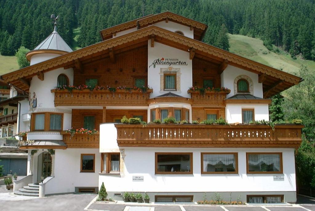 duży budynek z balkonem na górze w obiekcie Pension Rosengarten w mieście Tux