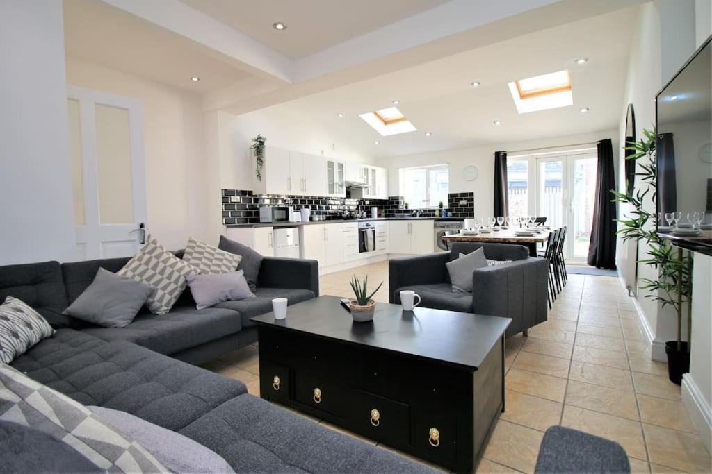 een woonkamer met een bank en een tafel bij Large Modern House by Property Promise in Cardiff