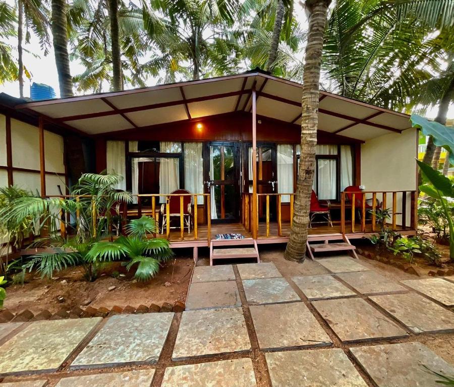a house with a porch with chairs and a patio at Jardim a Mar in Agonda