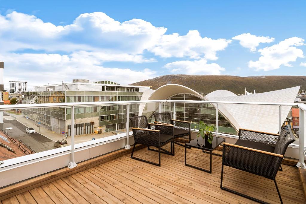 un balcone con sedie e tavoli su un edificio di The View a Tromsø