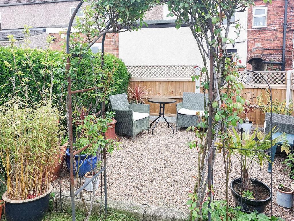 um jardim com mesa, cadeiras e plantas em Amberley Cottage em Alfreton