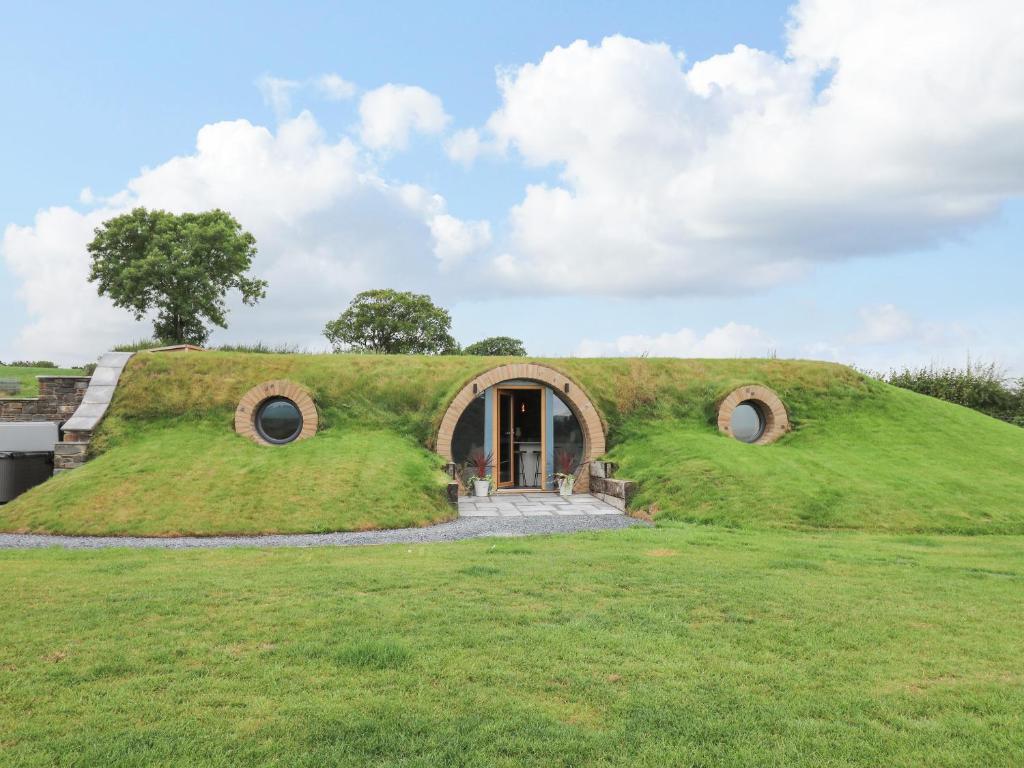 a grassy house with a door in a field at Tan Y Wawr in Welshpool