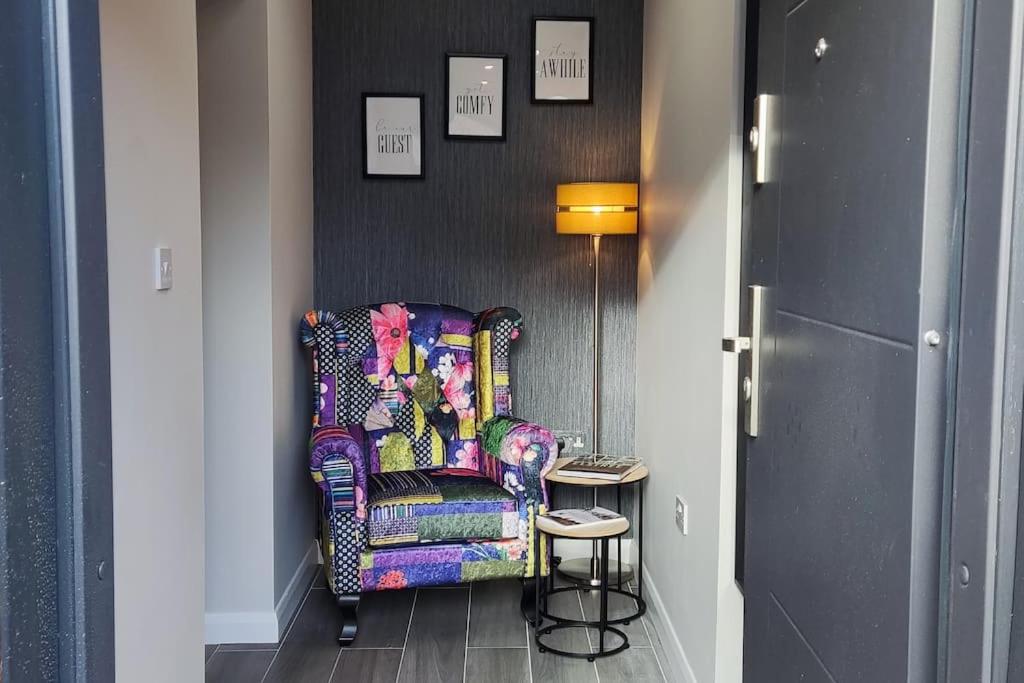 a colorful chair in a hallway with a side table at Comfortable 1 Bed flat with Air Con in Borehamwood