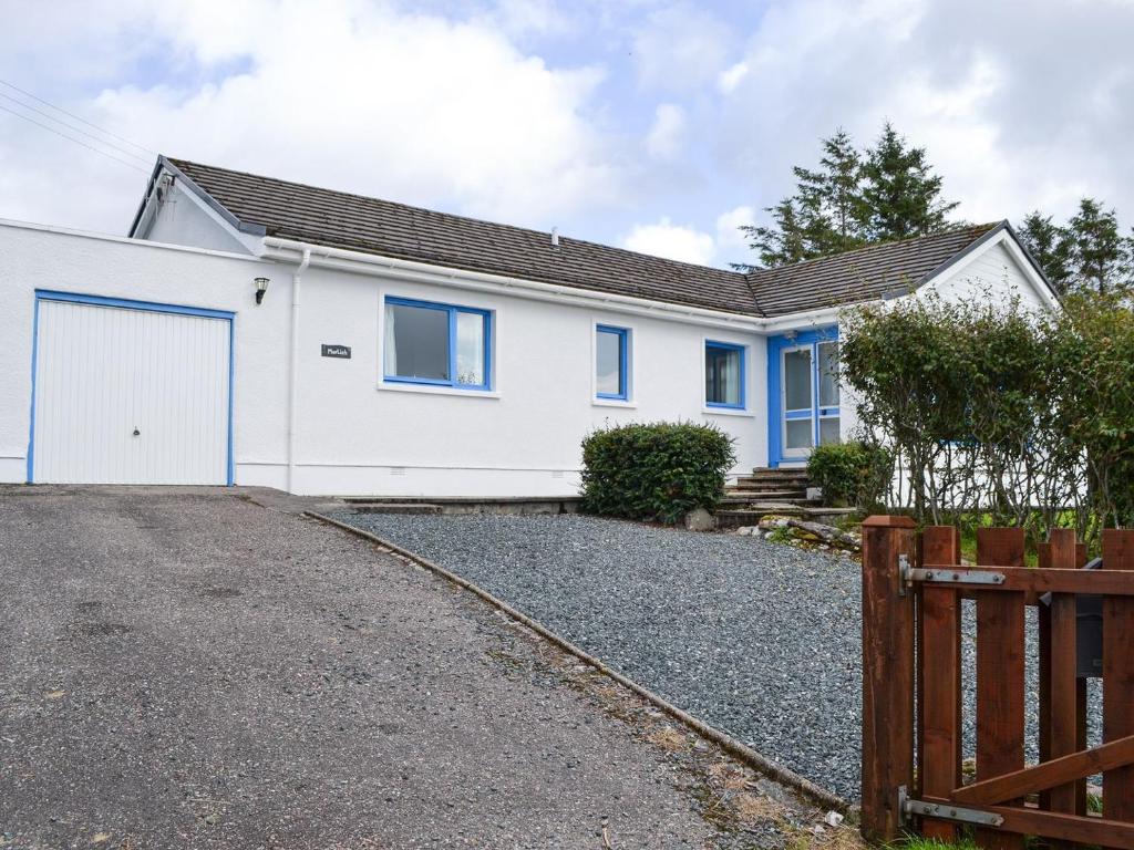 a white house with blue windows and a driveway at Morlich in Gairloch