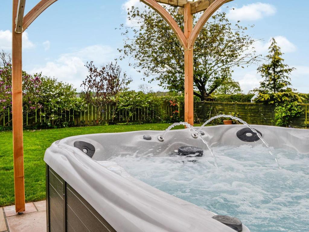 a hot tub in a backyard with a gazebo at Mount Farm - The Stable in Harker