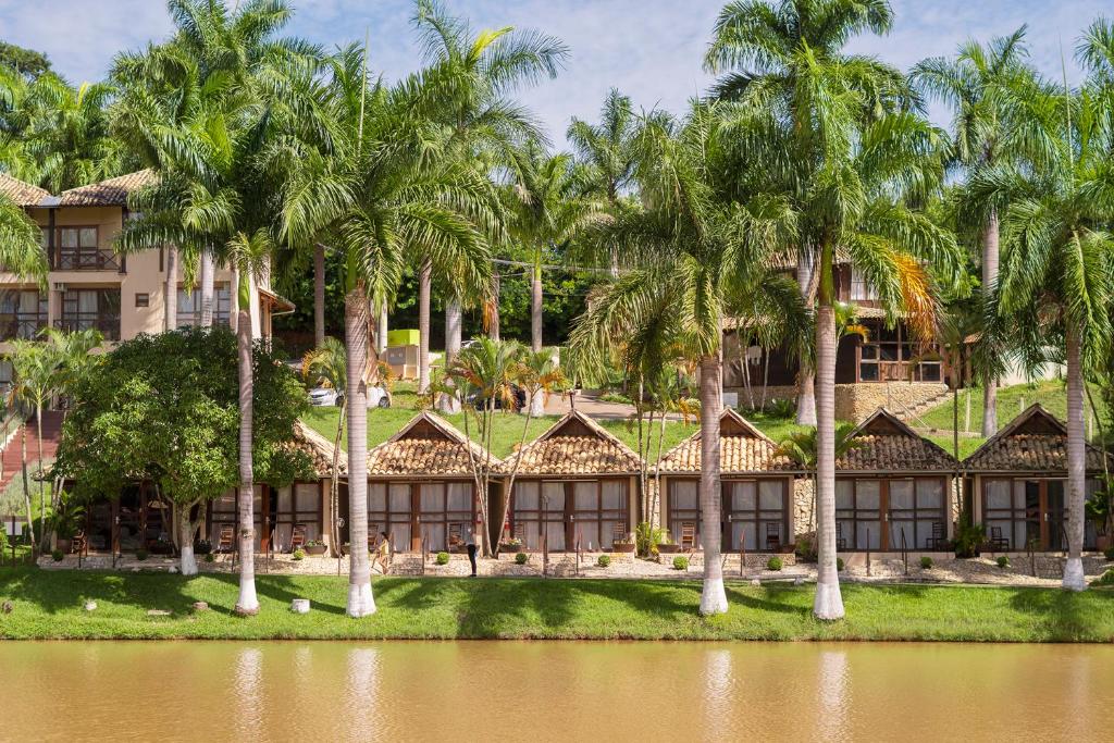 an exterior view of a resort with palm trees at Park Hotel Modelo in Pinhalzinho
