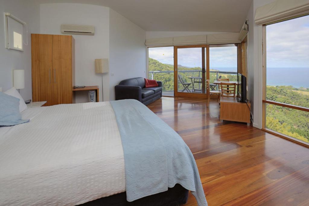 a bedroom with a bed and a view of the ocean at Chris's Beacon Point Restaurant & Villas in Apollo Bay