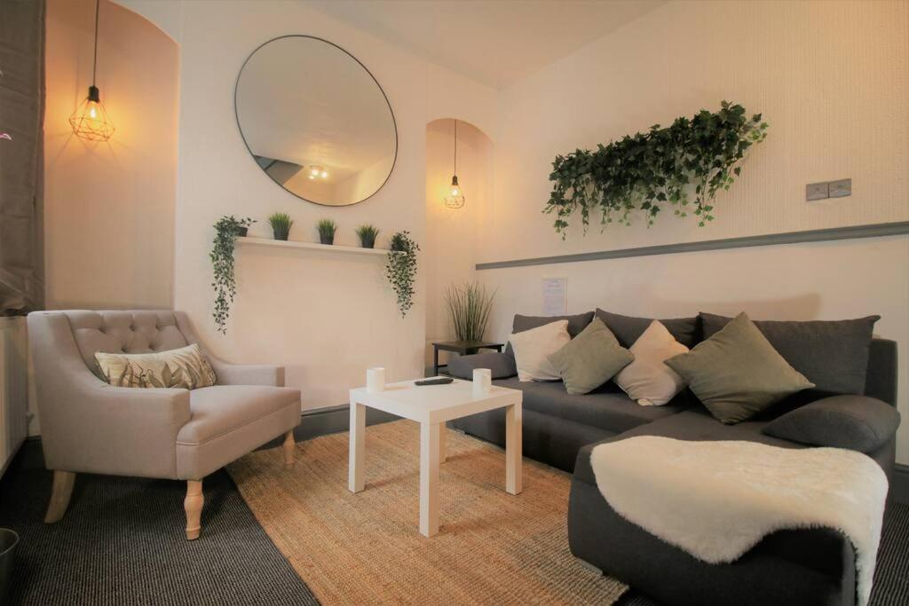 a living room with a couch and a chair at Fitzroy Terrace by Property Promise in Cardiff