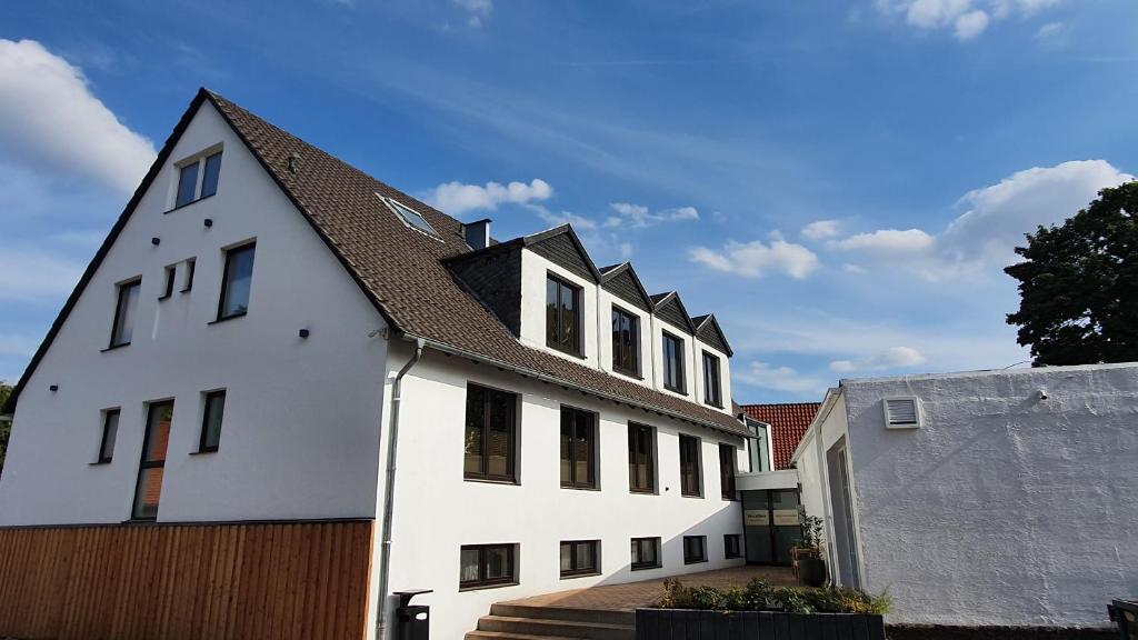 a white building with a brown roof at Altes Zollhaus Hülperode in Hülperode