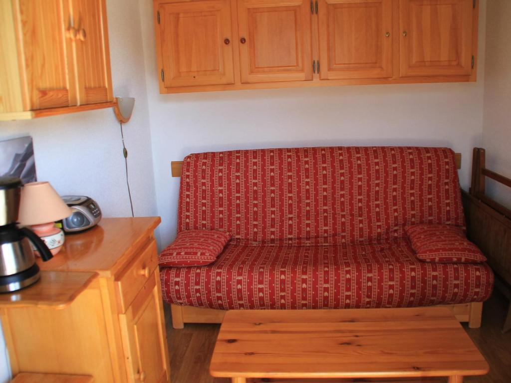 シャテルにあるAppartement Châtel, 2 pièces, 4 personnes - FR-1-200-146の木製テーブル付きキッチン(赤いソファ付)
