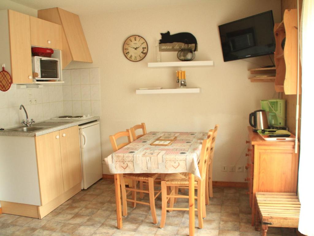 a kitchen with a table and chairs and a clock on the wall at Studio Châtel, 1 pièce, 4 personnes - FR-1-200-137 in Châtel