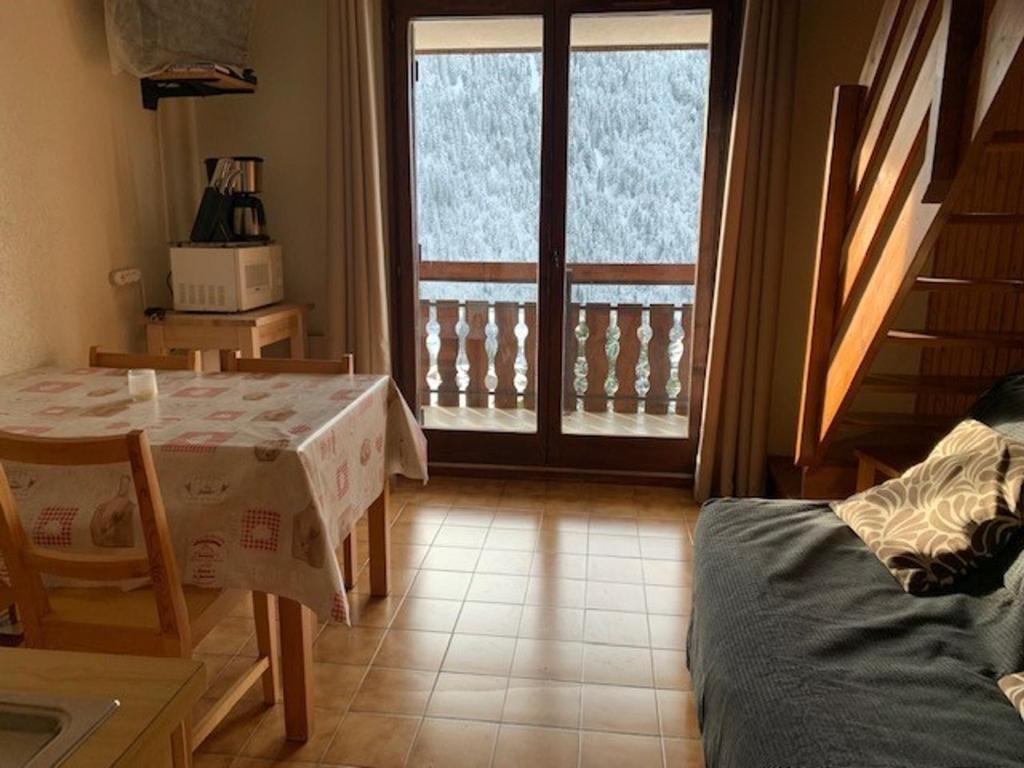 d'un salon avec une table et un balcon. dans l'établissement Appartement Châtel, 2 pièces, 4 personnes - FR-1-200-152, à Châtel