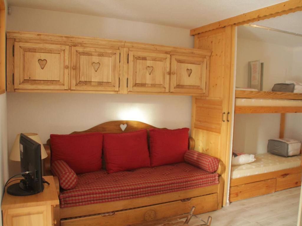 シャテルにあるStudio Châtel, 1 pièce, 4 personnes - FR-1-200-172の二段ベッド付きの客室で、ソファ(赤い枕付)が備わります。