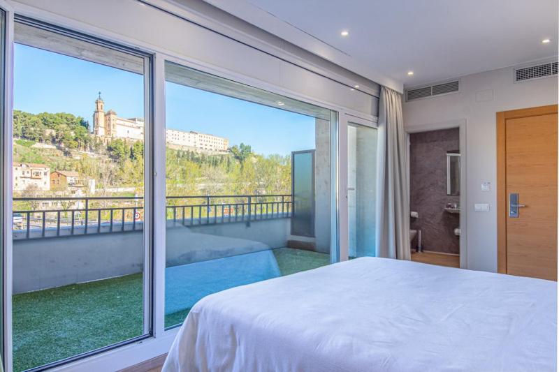 Schlafzimmer mit einem großen Fenster und einem Bett mit Aussicht in der Unterkunft HOTEL JAUME D'URGELL in Balaguer