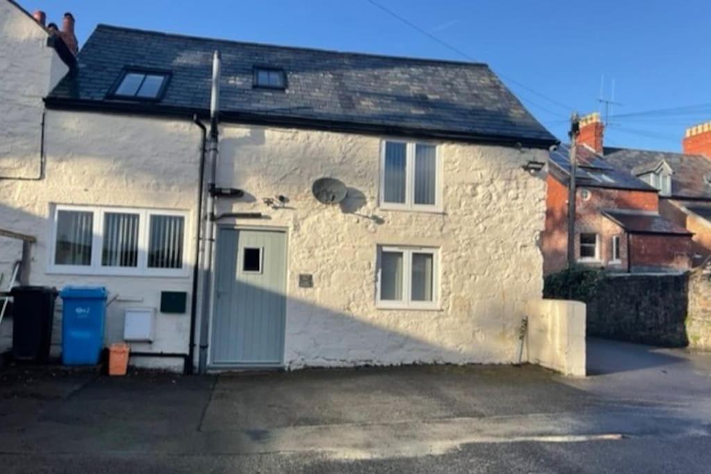 a stone house with a green door on the side of it at Y Stabl 94a in Denbigh