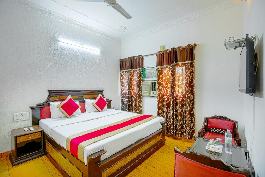 ein Schlafzimmer mit einem Bett und einem TV in der Unterkunft HOTEL ARINA in Chandīgarh