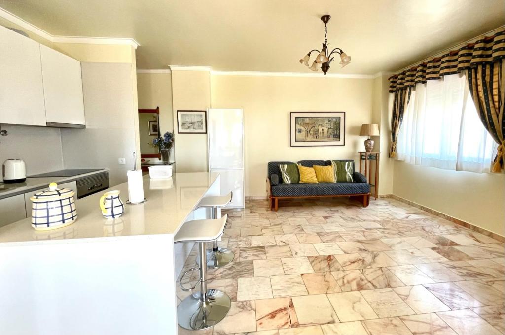 een keuken en een woonkamer met een bank bij Cosy Sea View Apartment in Costa da Caparica