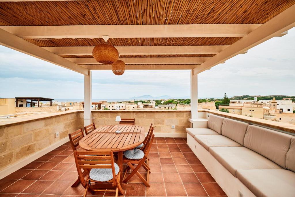 um pátio com uma mesa e cadeiras numa varanda em Casa Piti Stunning View em Favignana