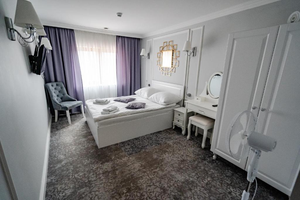 1 dormitorio con cama, escritorio y espejo en Pokoje gościnne Biała Dama, en Mławka