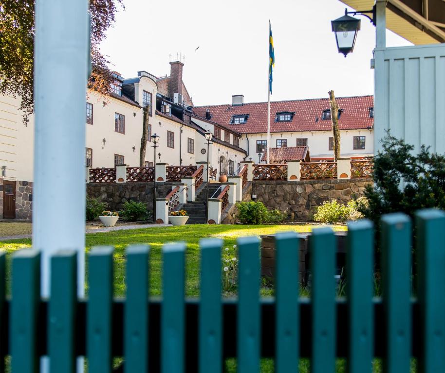 a green fence with buildings in the background at Värdshuset Hwitan in Falkenberg