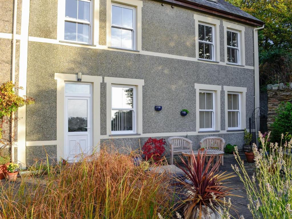 a house with a white door and chairs in the yard at Cilgwyn in Llandecwyn