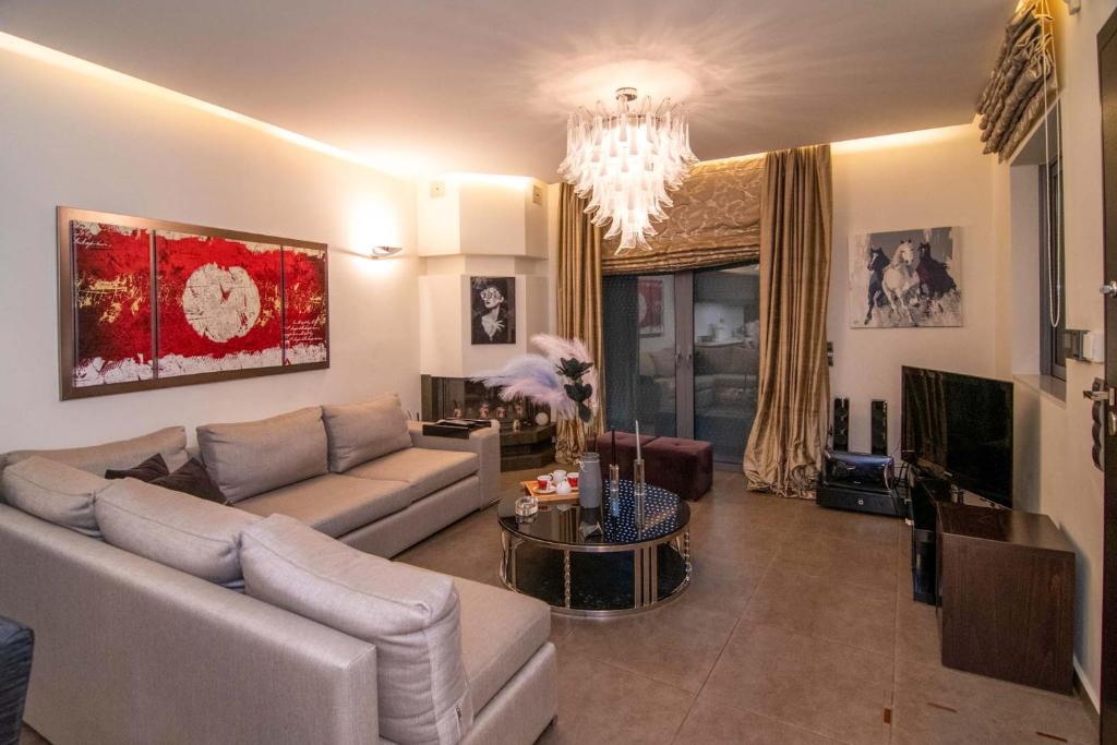 a living room with a couch and a chandelier at Optasia Luxury House in Argos