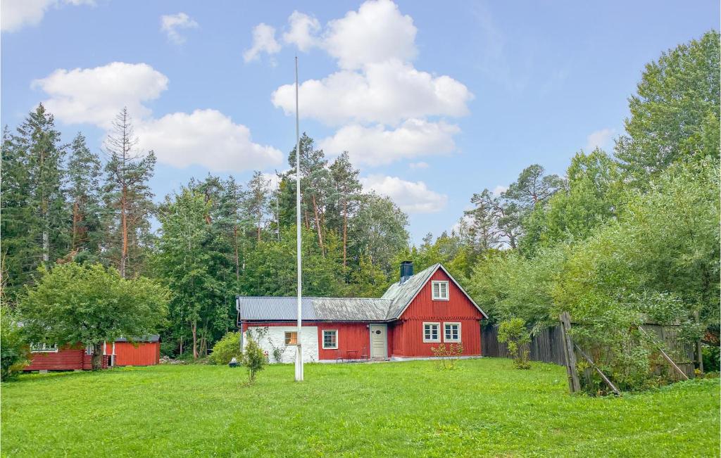 uma casa vermelha no meio de um campo de relva em 3 Bedroom Amazing Home In Lrbro em Lärbro