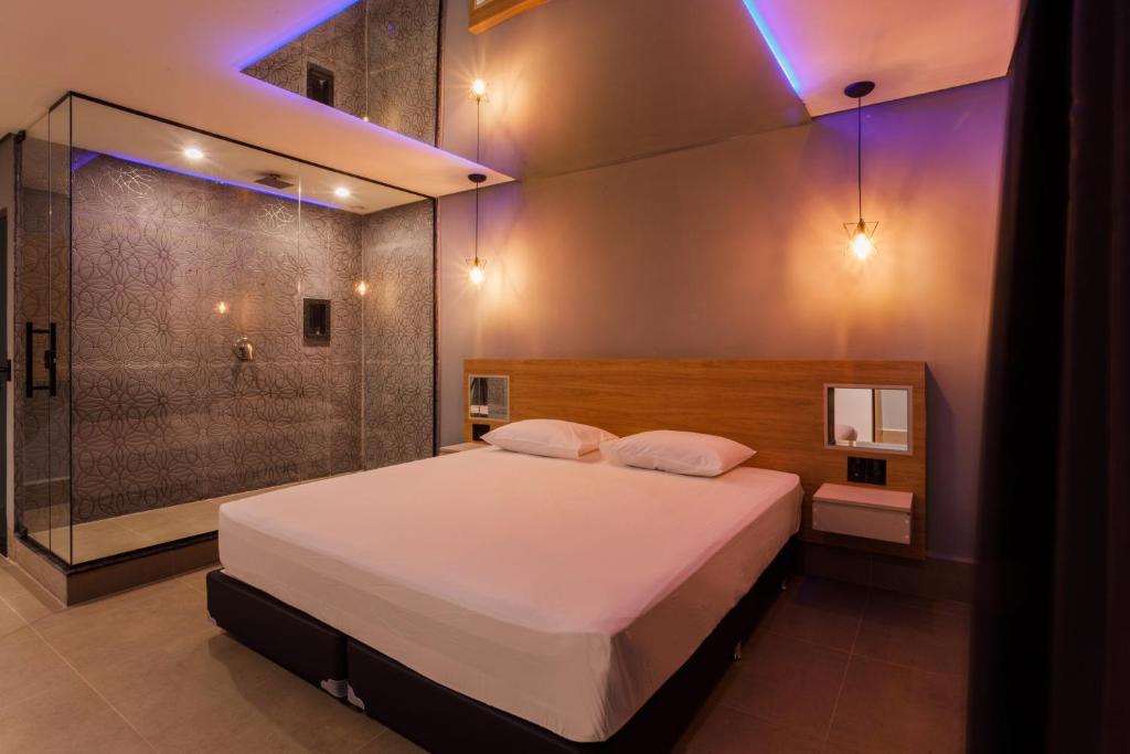 Drops Express Motel في باريتوس: غرفة نوم مع سرير كبير ودش