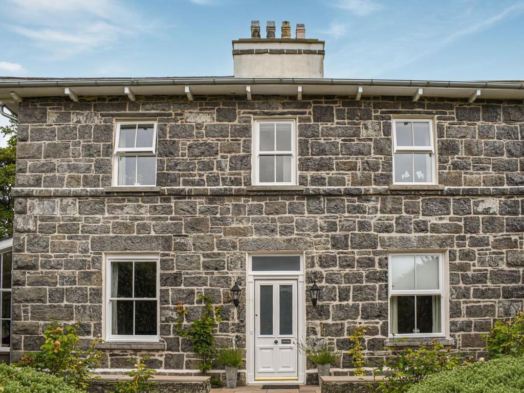 a stone house with a white door and windows at Castle View - Ukc5701 in Castletown
